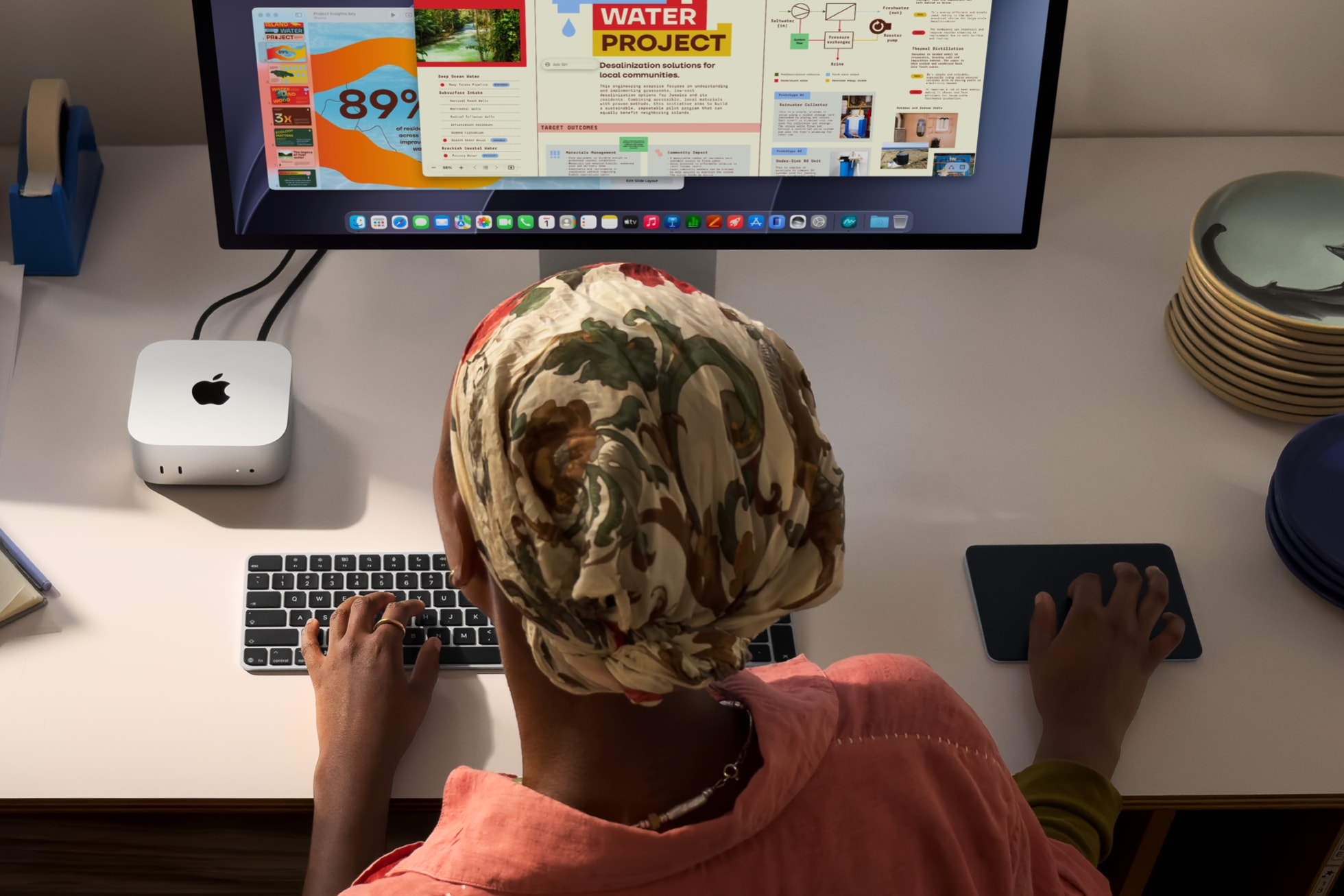 A person working at a desk with the new Mac mini connected to a display